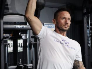 Personal trainer in Galway performing kettlebell press in Galway City Gym, demonstrating correct form and strength during a personal training session, Jason Cafferkey.